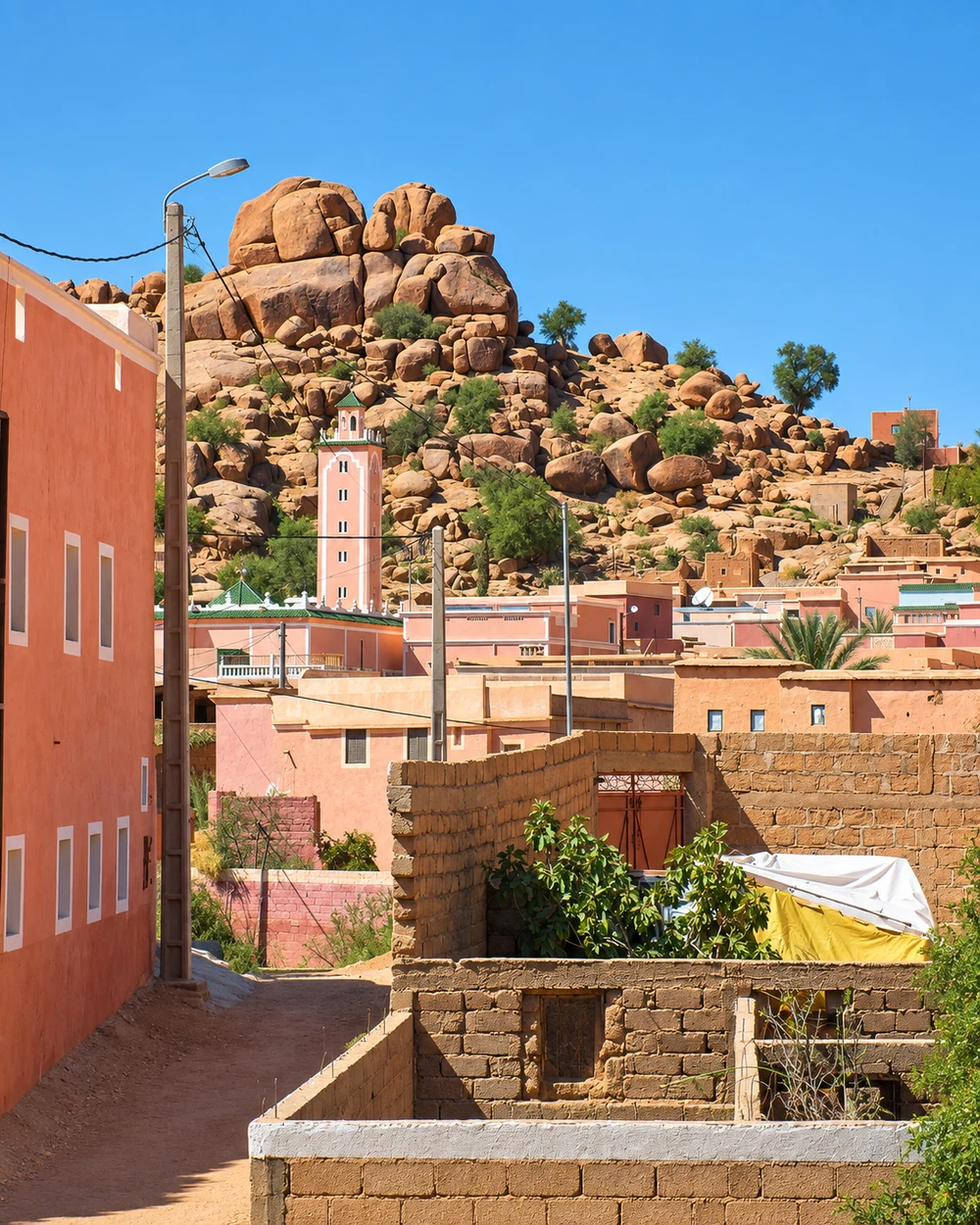 Rose-coloured houses and a minaret beneath rounded granite boulders