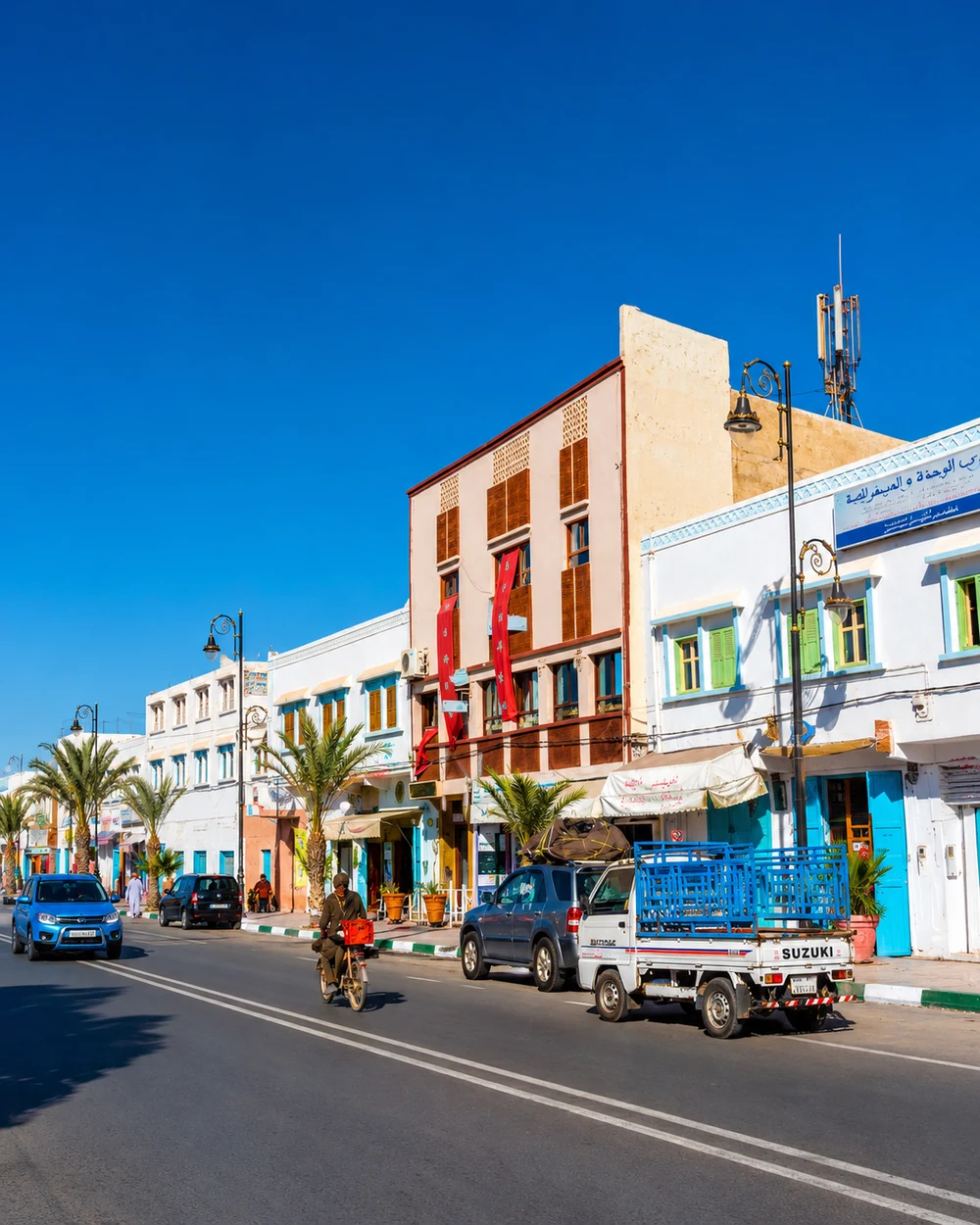 Shopfronts and vehicles along a Tan-Tan street