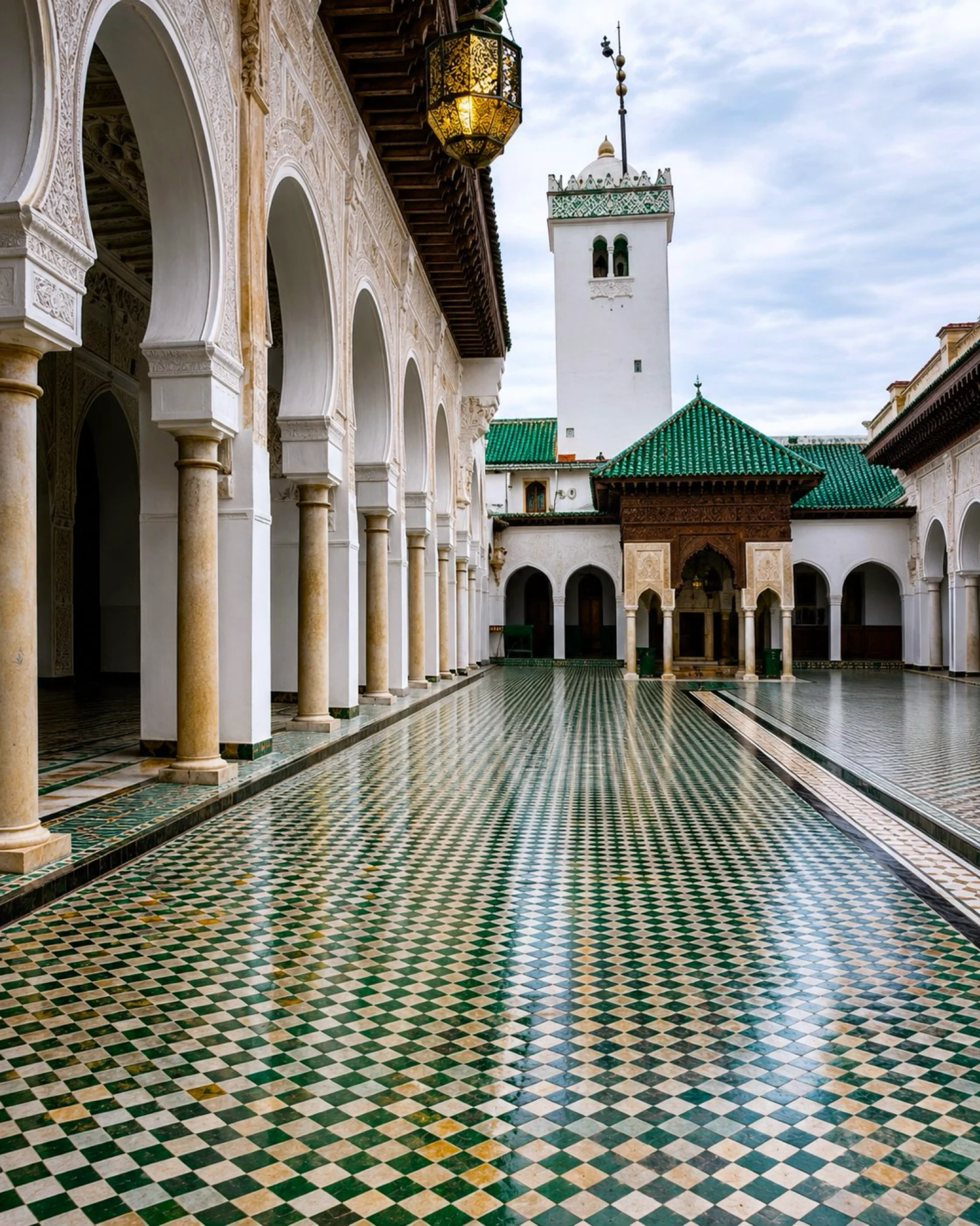 Al Quaraouiyine Quarter courtyard with green zellige and white arches in Fès, Morocco