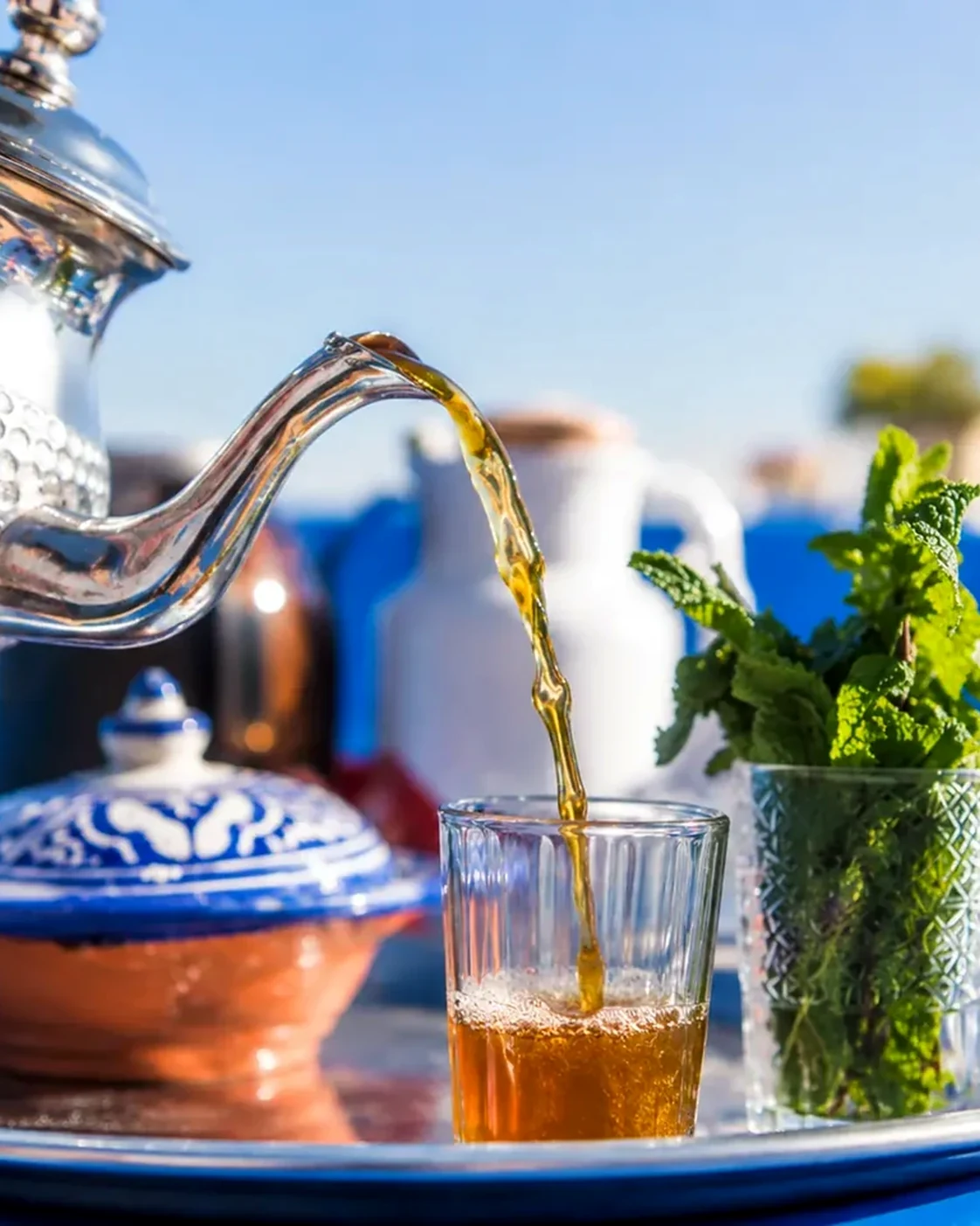 Moroccan mint tea being poured into a decorated glass