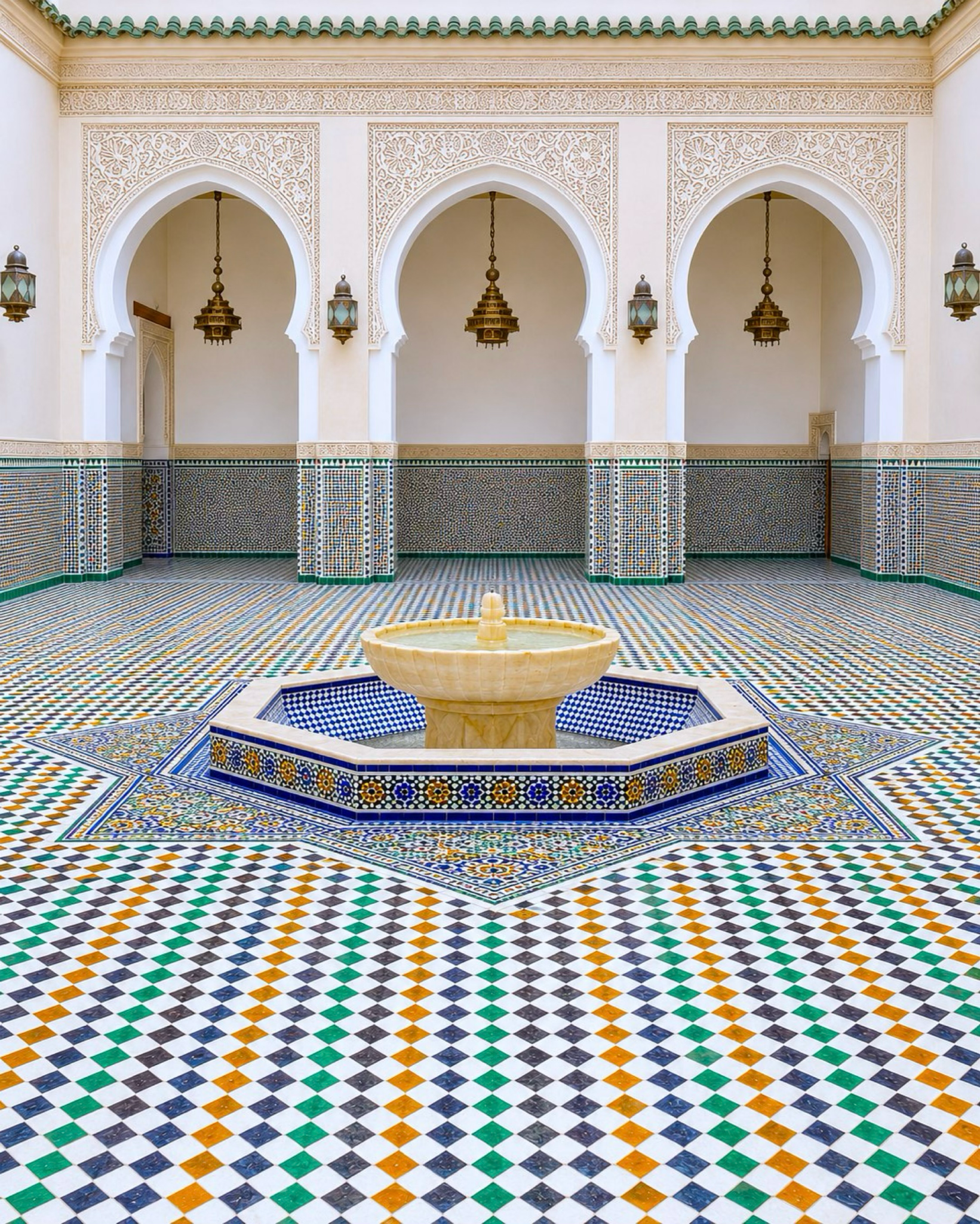 Moroccan courtyard fountain framed by arches and geometric zellige