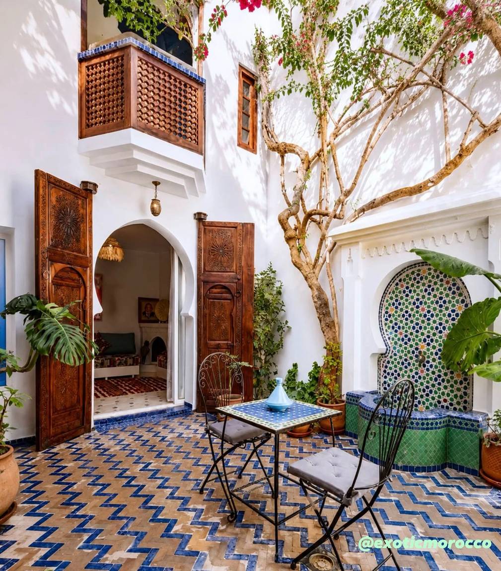 Moroccan riad courtyard with zellige and carved wood