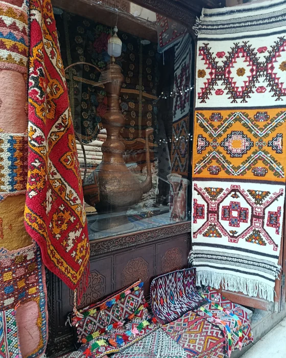 Woven textiles and patterned rugs displayed at a Moroccan shop