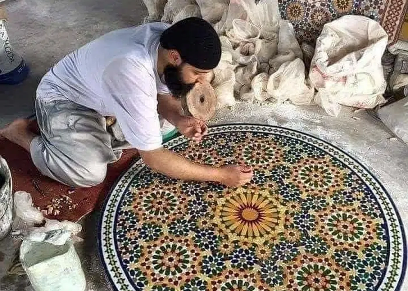 A mosaic maker at an assembly bench.