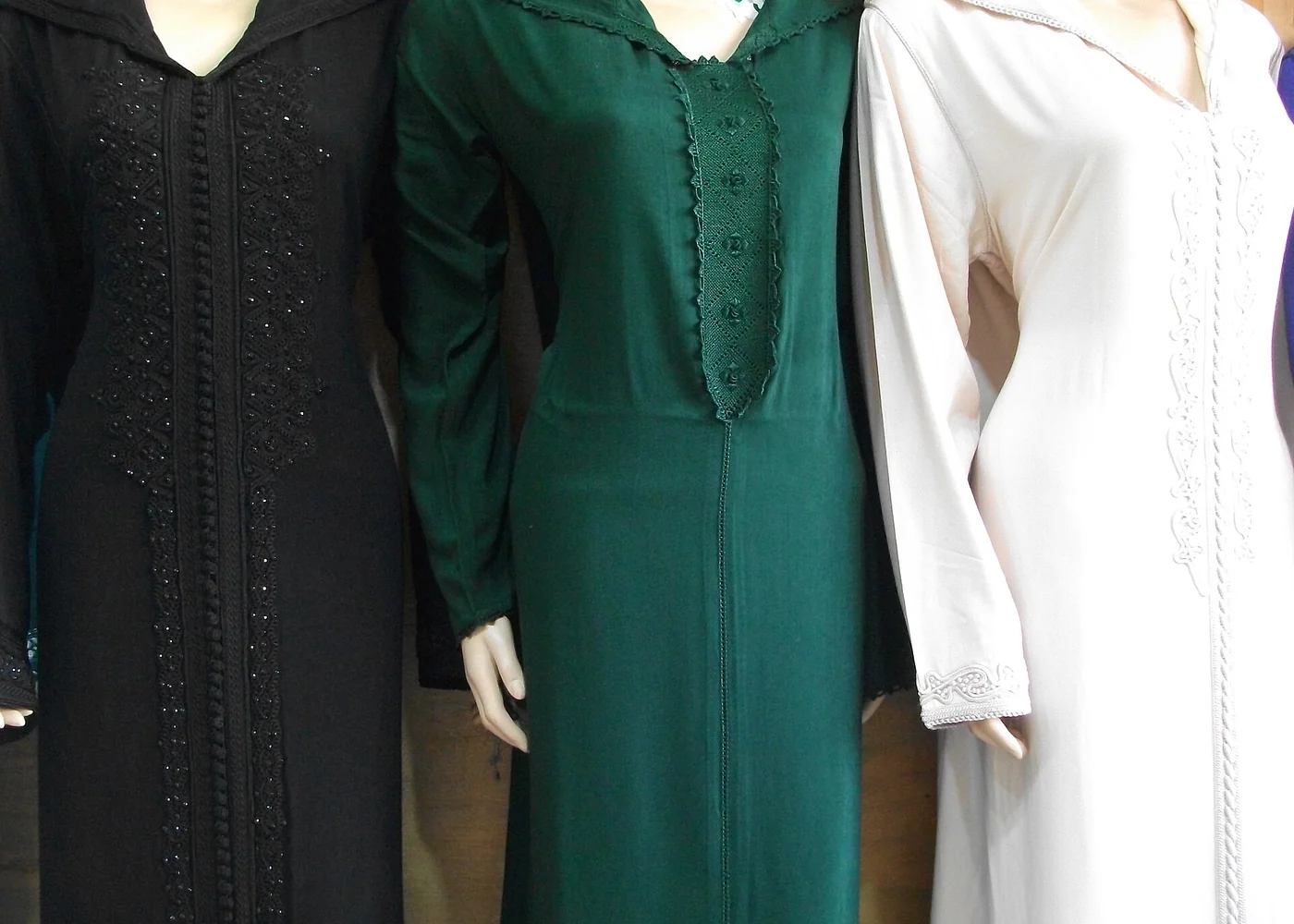 Djellabas displayed on forms in a shop.