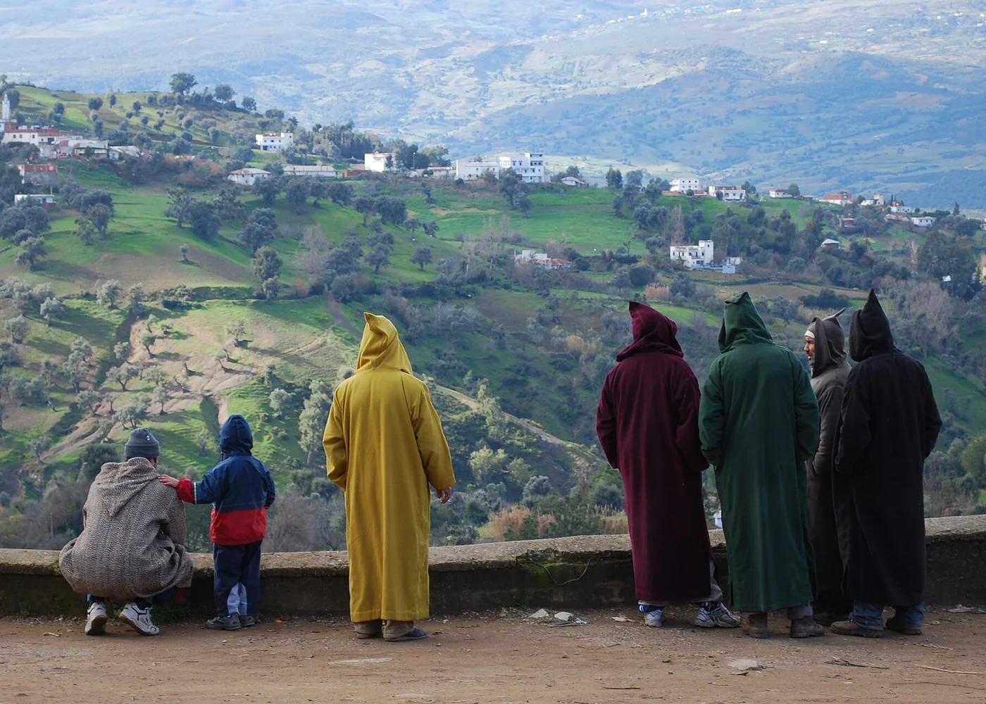 Men wearing djellabas at a market in Chefchaouen.