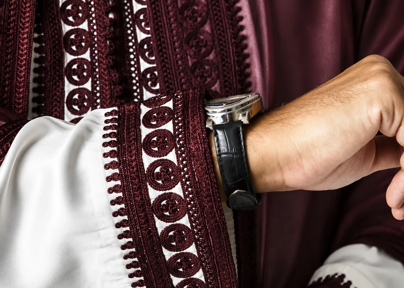 Braided trim and buttons at the edge of a garment.