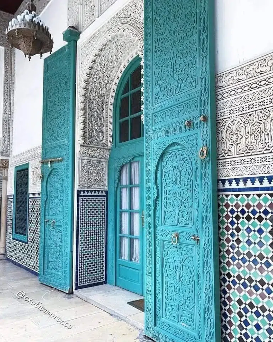 Painted doors framed by tile and carved plaster.