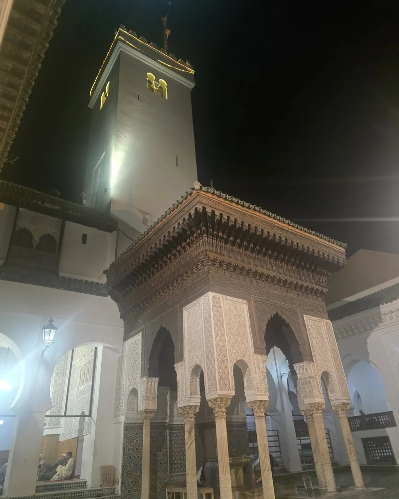 A courtyard pavilion, minaret, carved stucco and cedar at Al-Qarawiyyin.