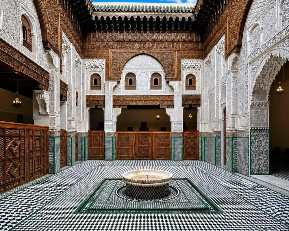 Meknès madrasa courtyard · urban craft context, not a riad.