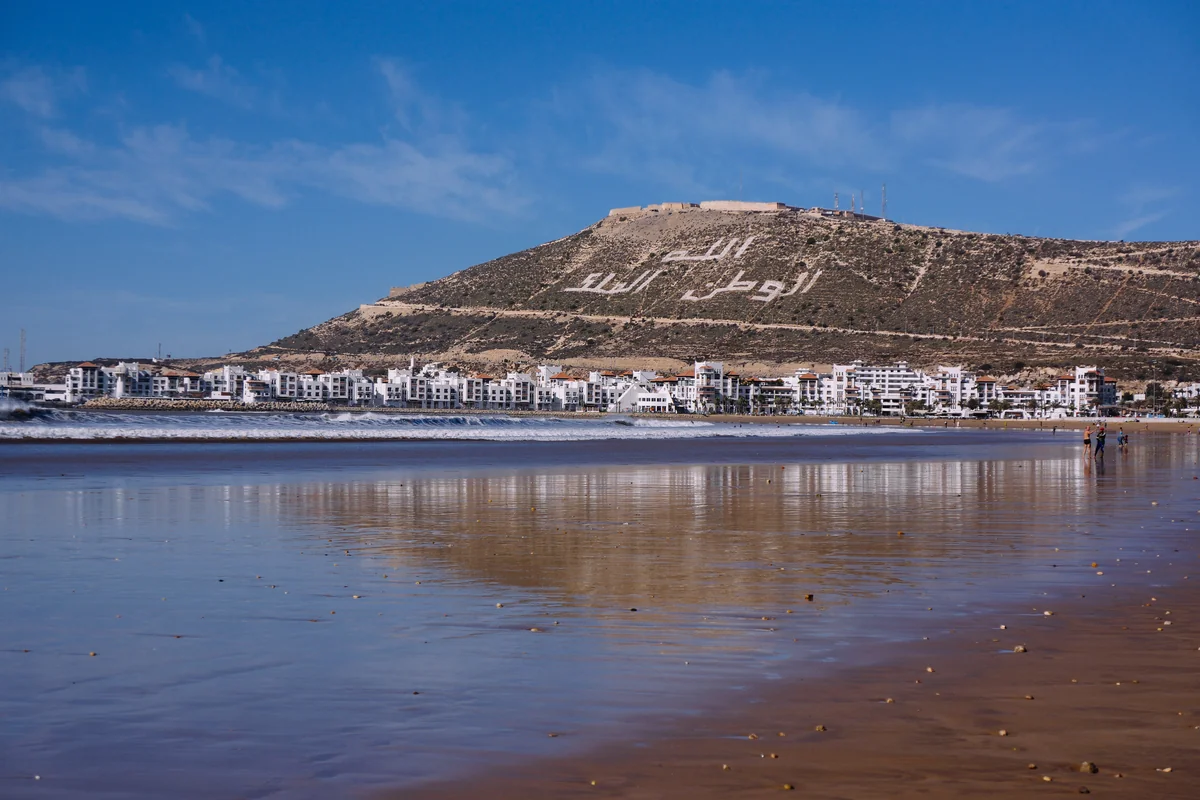 Agadir waterfront reflected in wet sand at low tide