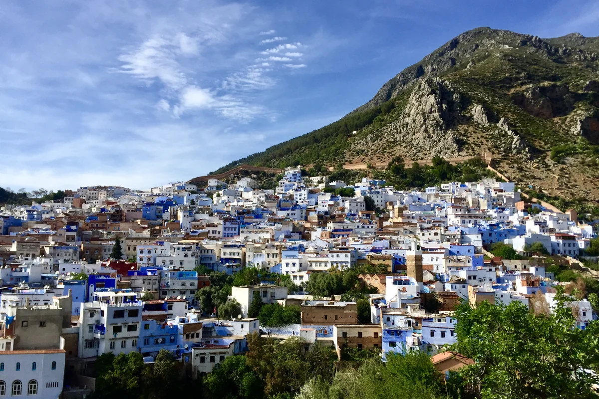 Chefchaouen houses spread beneath the green mountain slopes