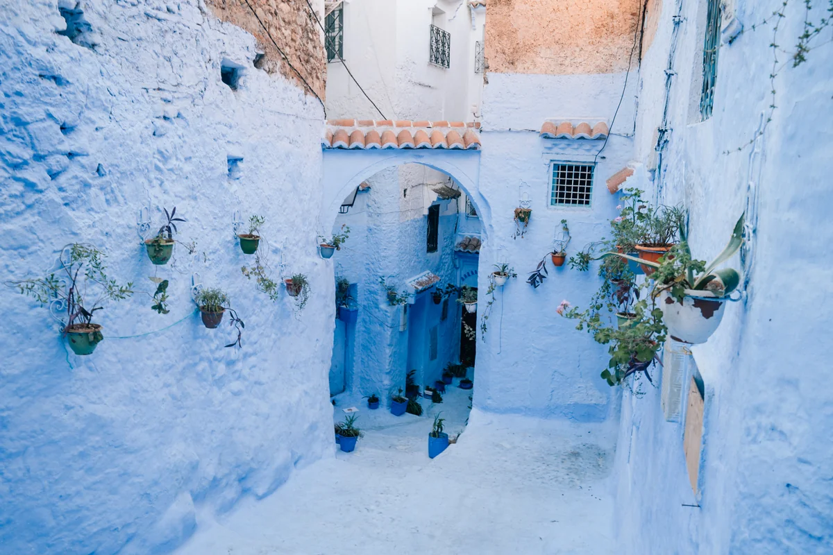A person walking through pale blue streets in Chefchaouen