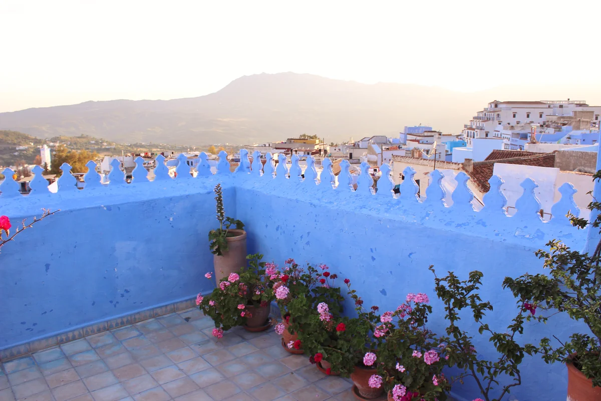 Pots of flowers along a blue terrace overlooking Chefchaouen