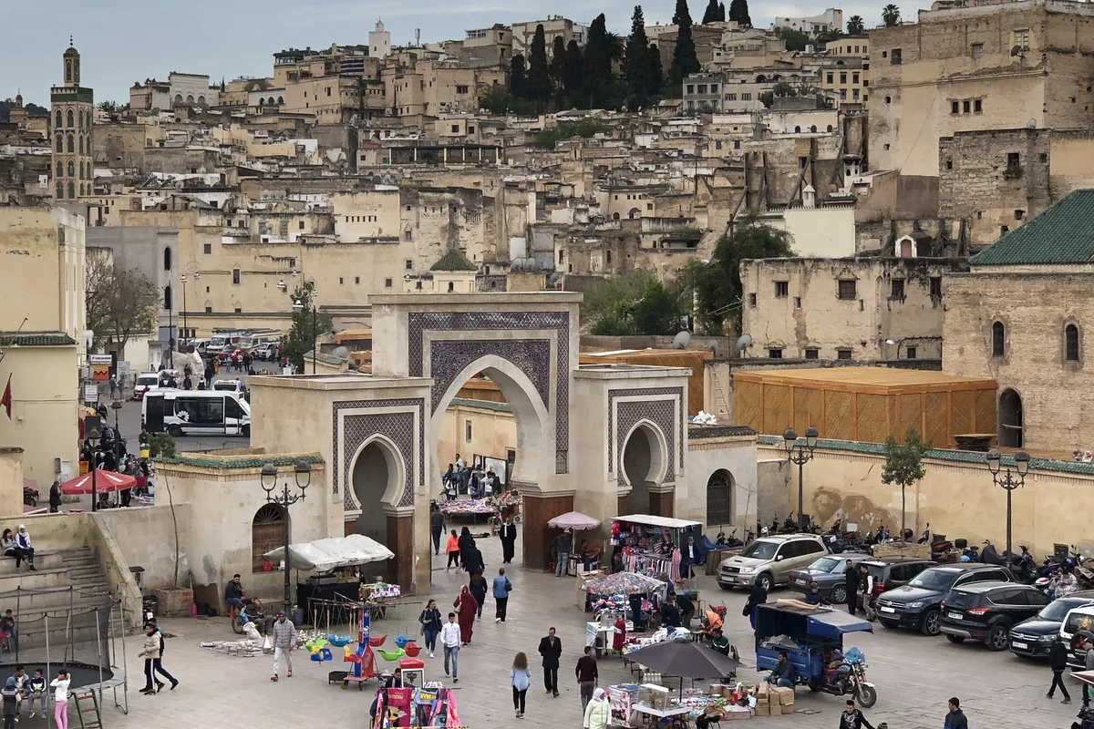 A monumental gateway below the densely built Fès medina