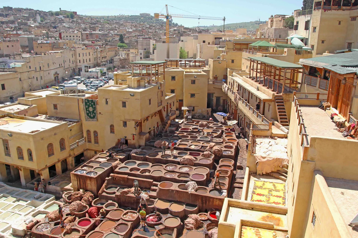 A sunlit view over the tannery vats and surrounding Fès rooftops