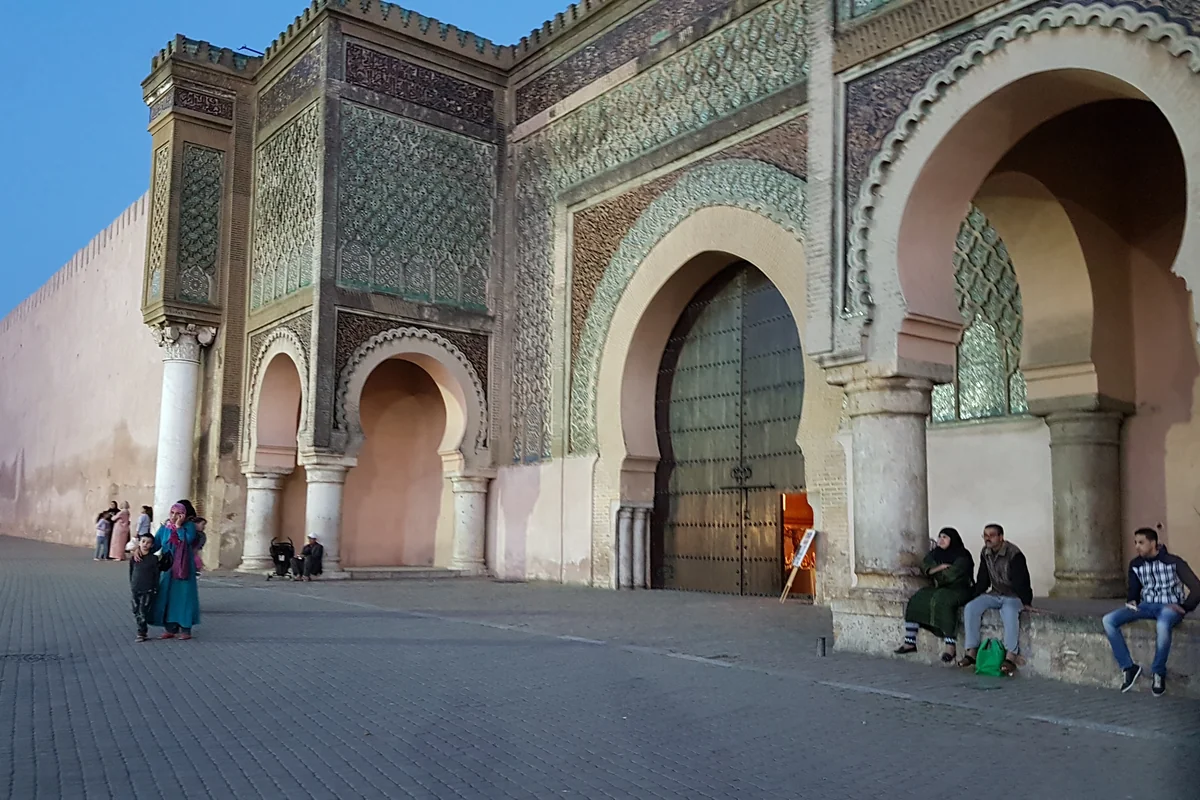 People passing the decorated arches of Bab Mansour in Meknès