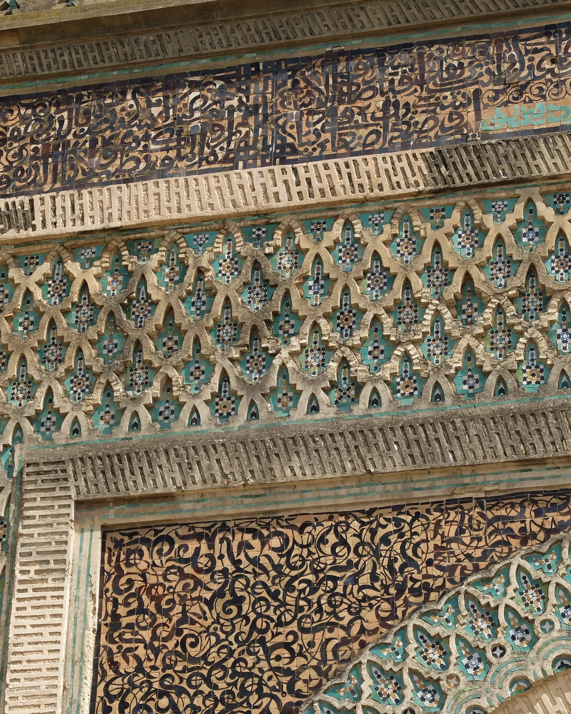 Bab Mansour’s surface in Meknès: tile, carved bands and large-scale composition work together.
