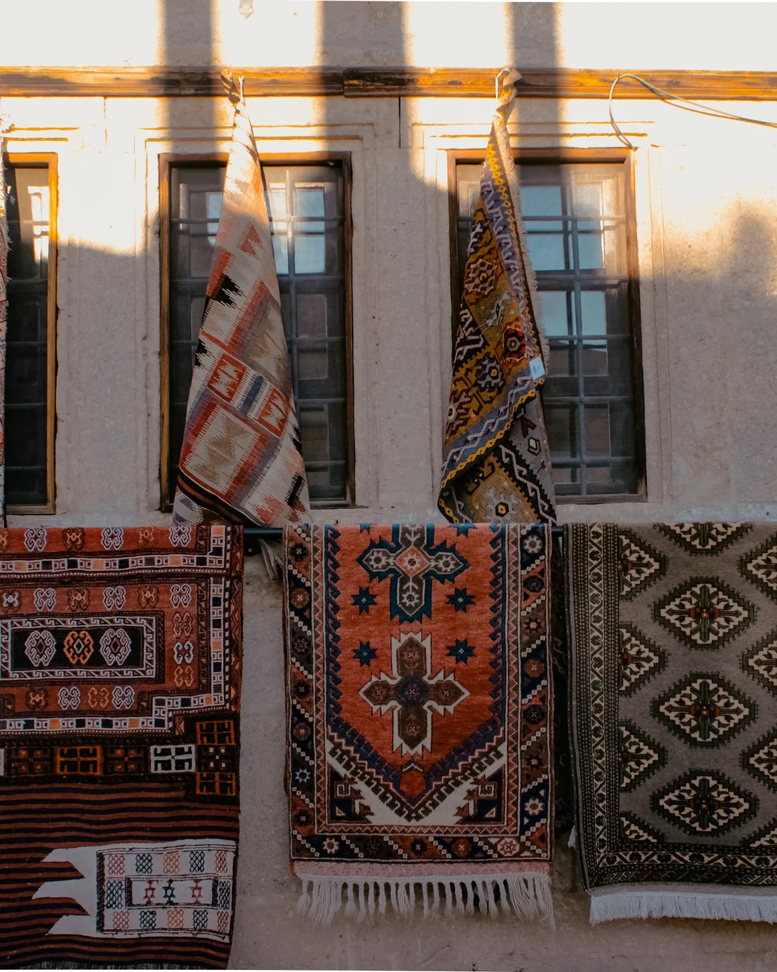 Textiles displayed for sale: ask about the maker and the work behind the finished piece.