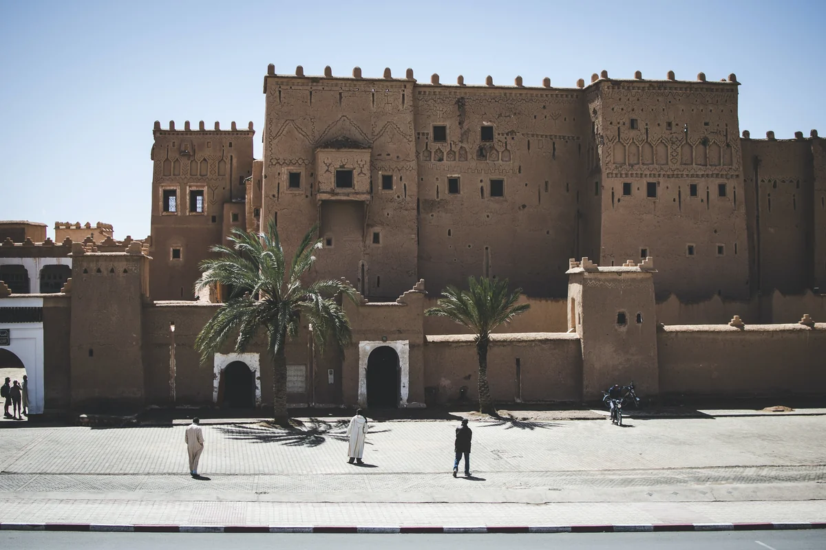 The earthen towers of Taourirt Kasbah above a street in Ouarzazate