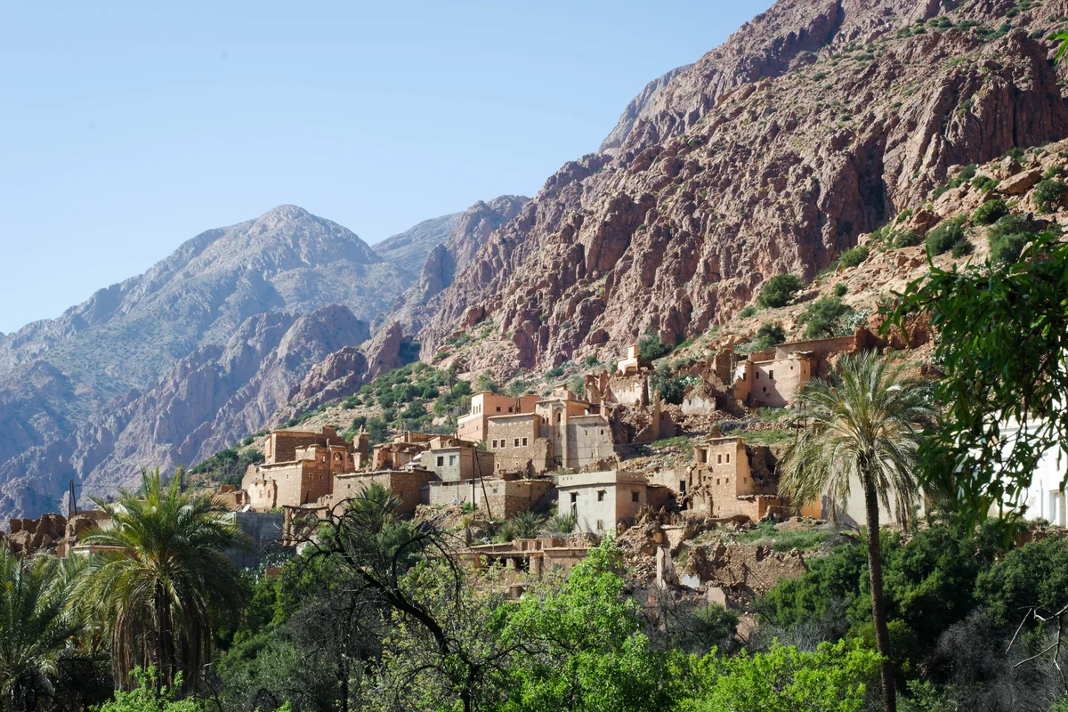 A village and palm trees beneath the rocky mountains around Tafraout