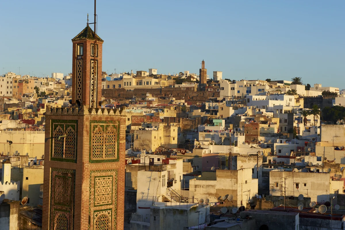 A decorated minaret rising above the rooftops of Tangier