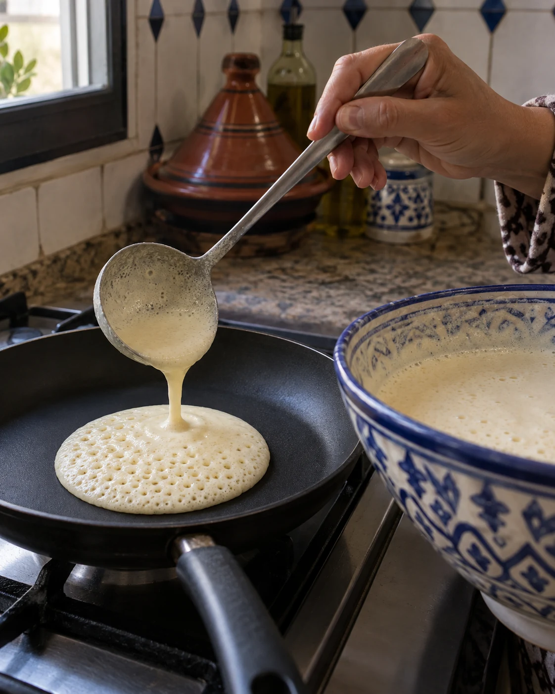 Semolina batter being poured into a pan for baghrir