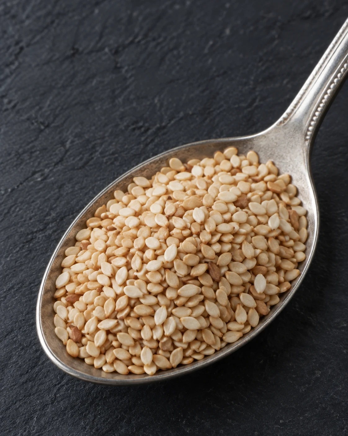 Small flat sesame seeds in a spoon