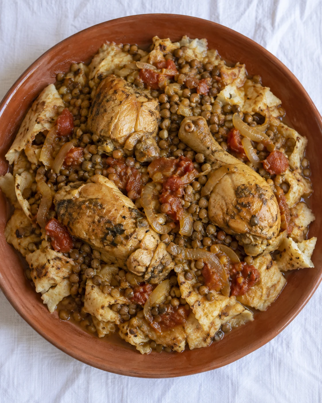 Chicken, lentils and tomato-rich broth over torn bread