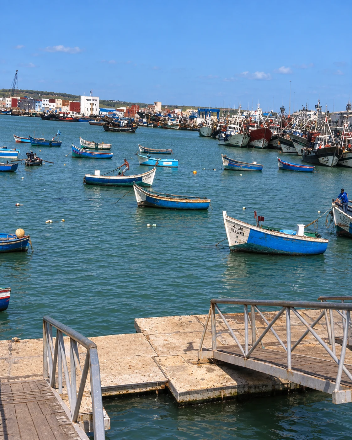Blue and white fishing boats in an editorial adaptation of a photograph of Larache’s harbour.