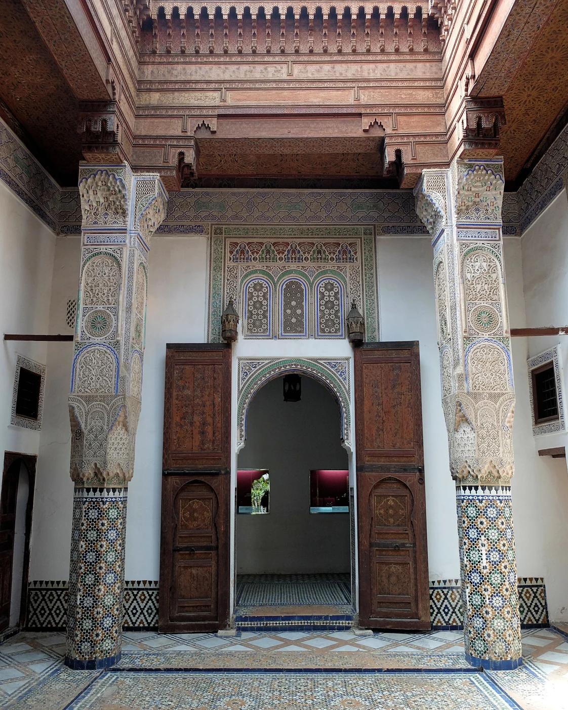Worked tile, carved plaster and wood around an interior doorway at Dar Jamaï in Meknès.