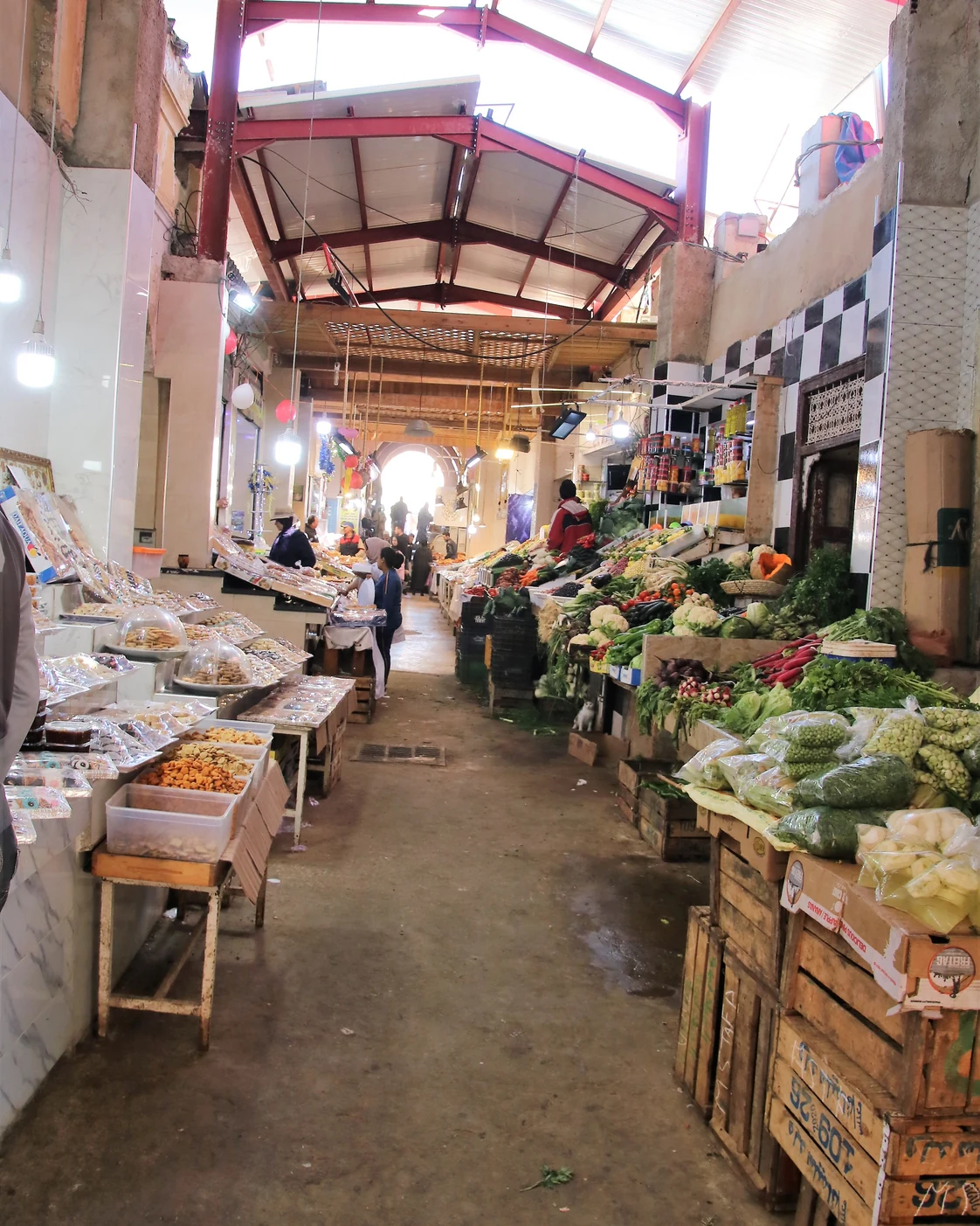 A covered market lane with displays of goods in Meknès.