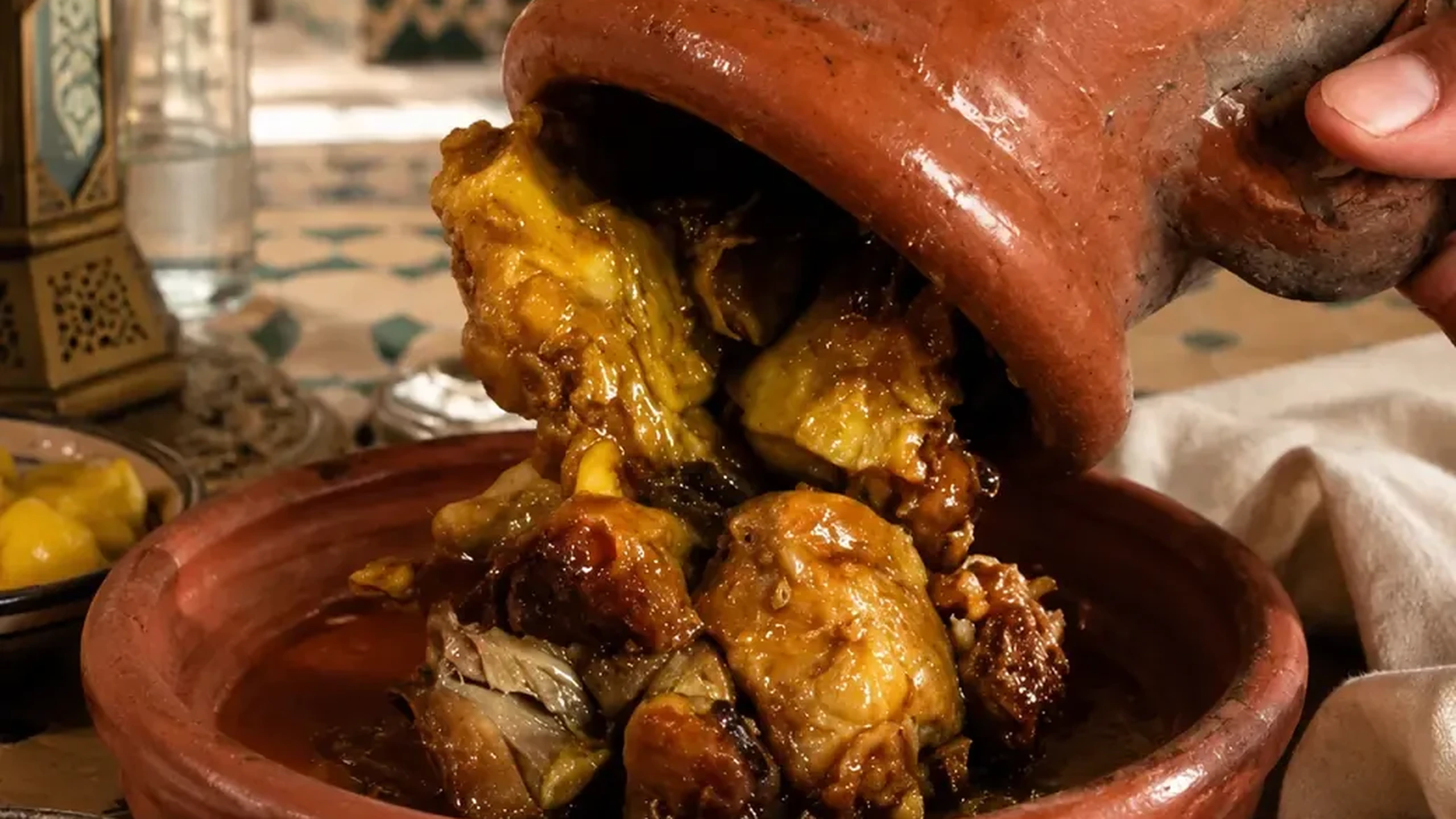 Slow-cooked tanjia being served from its clay vessel on a Marrakech table