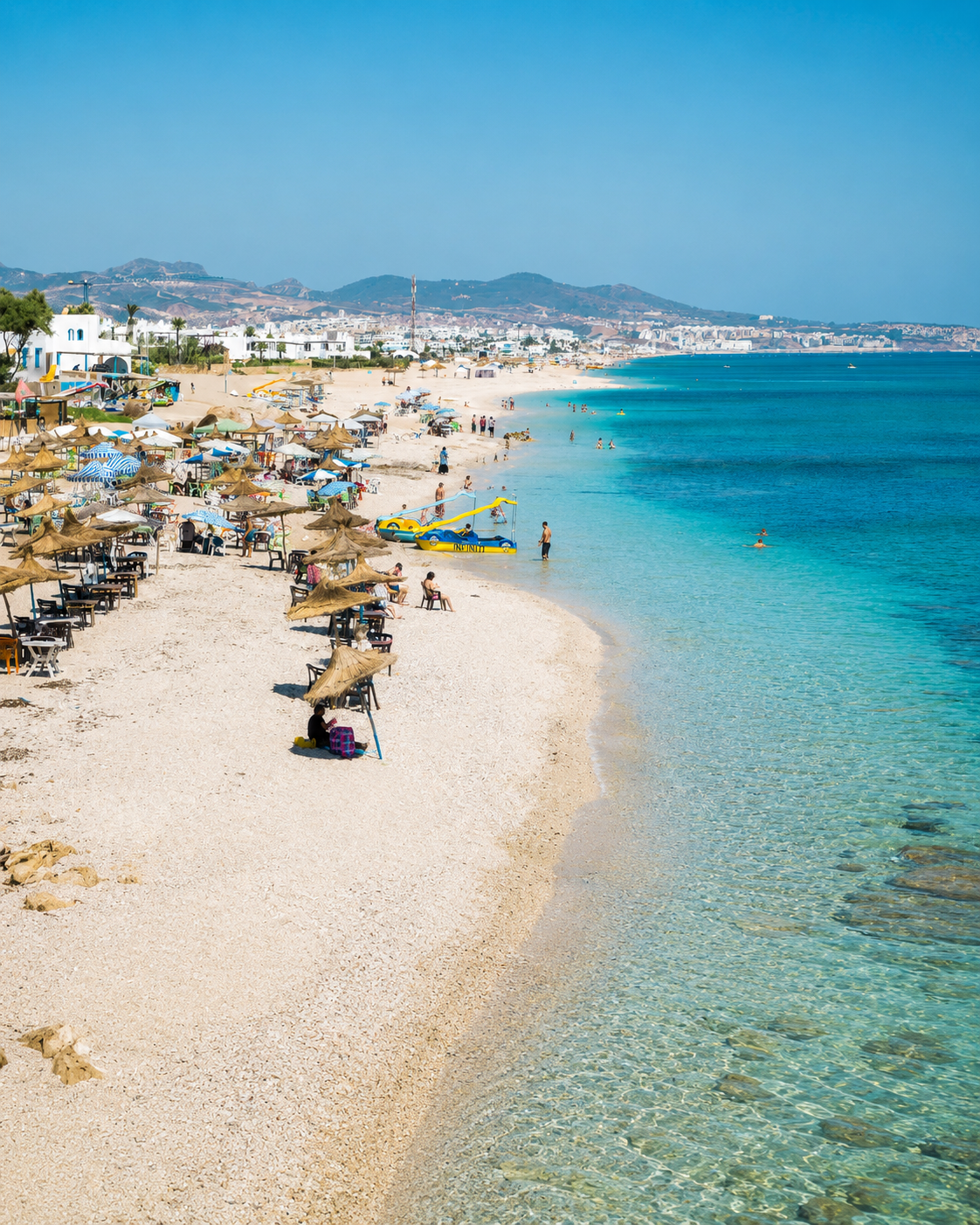 Beach umbrellas and clear shallow water on the Fnideq coast