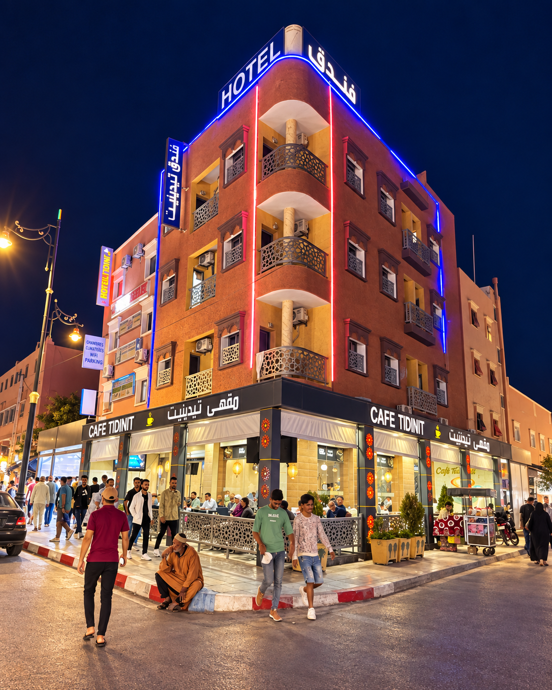 Illuminated hotel and café frontage with pedestrians at night