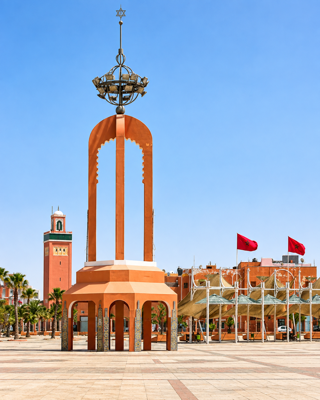 Orange civic monument with a metal finial at Place du Méchouar in Laâyoune