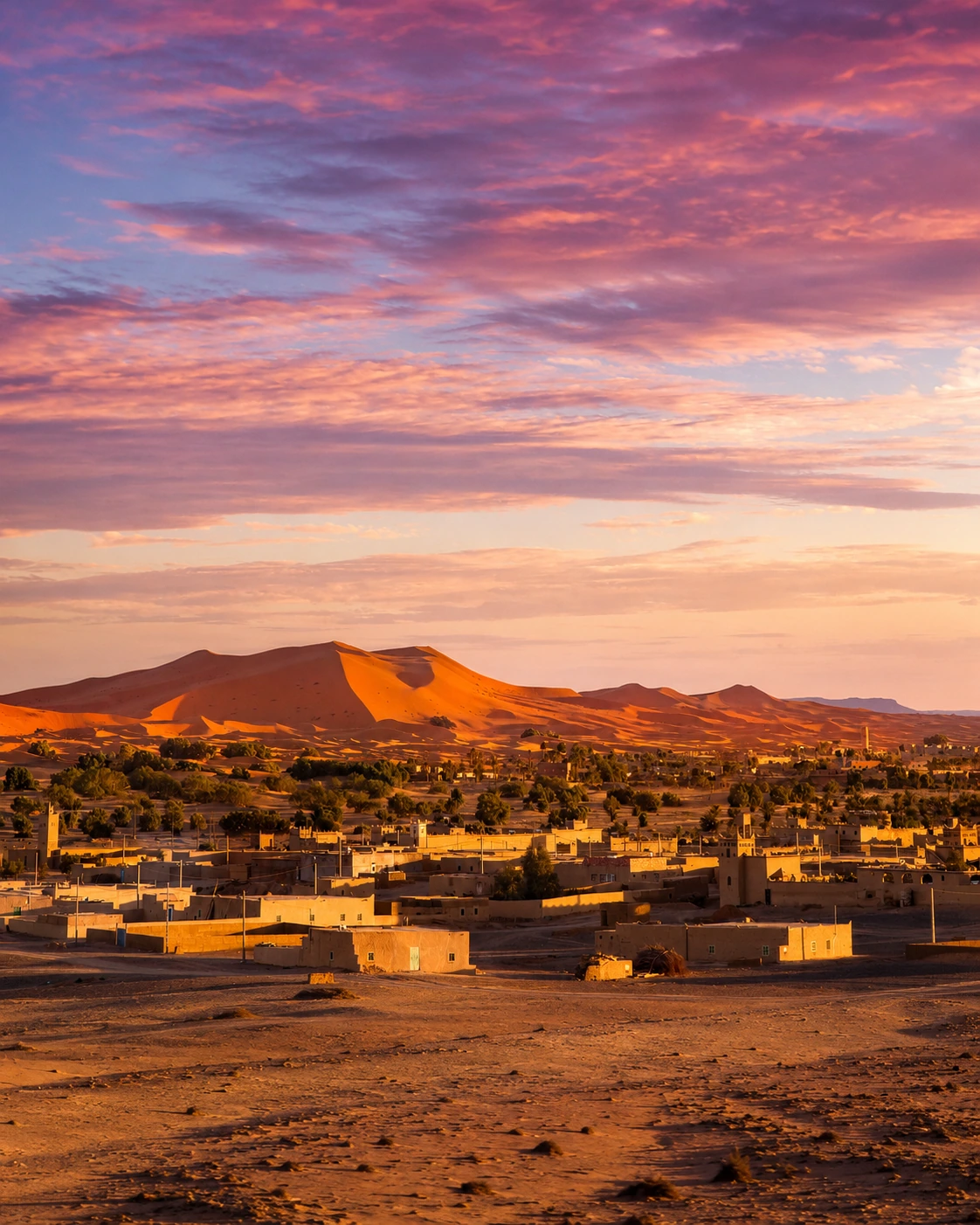 Merzouga village beneath the dunes at sunset