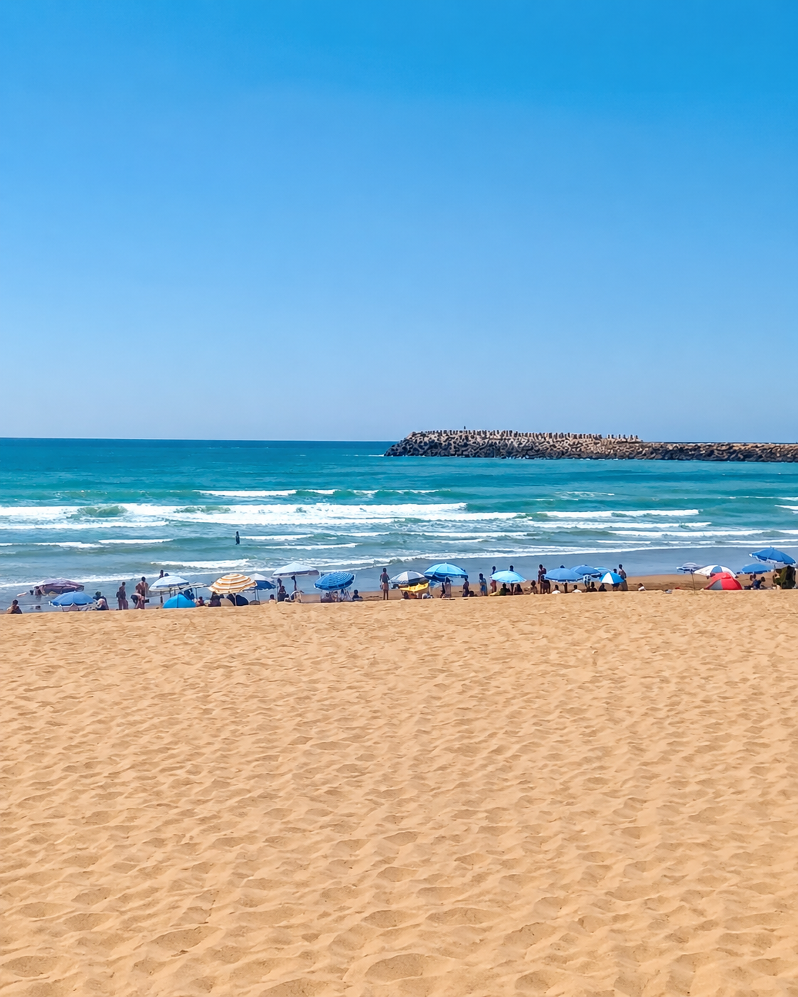 Broad sandy beach, Atlantic surf and the breakwater at Mehdia