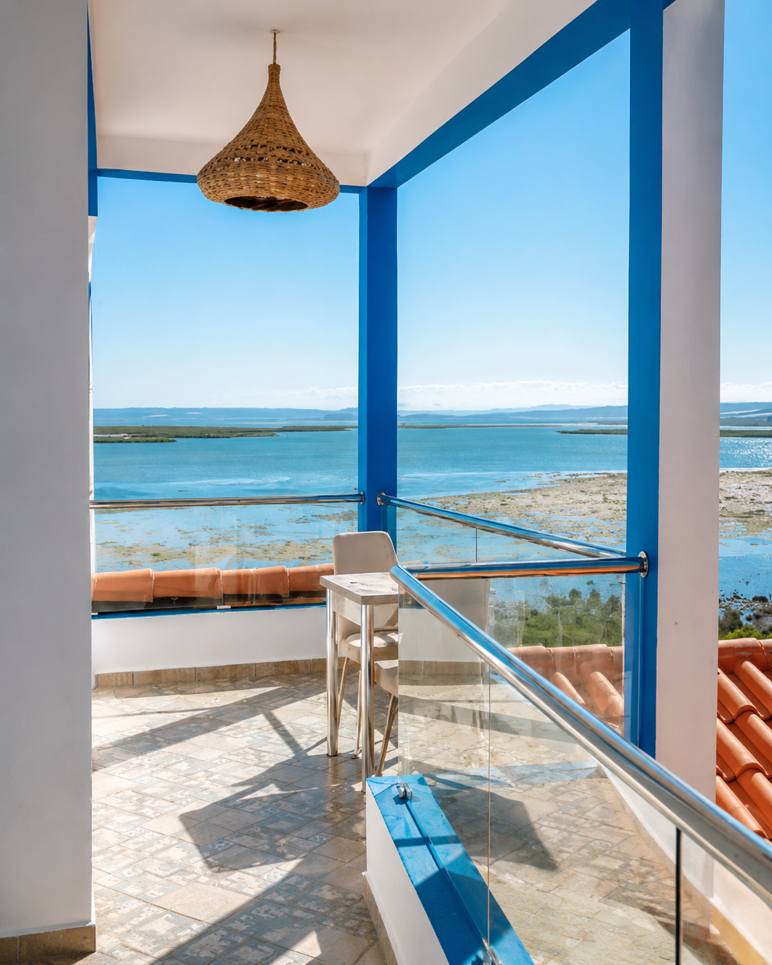 Blue framed balcony and woven lampshade overlooking the lagoon