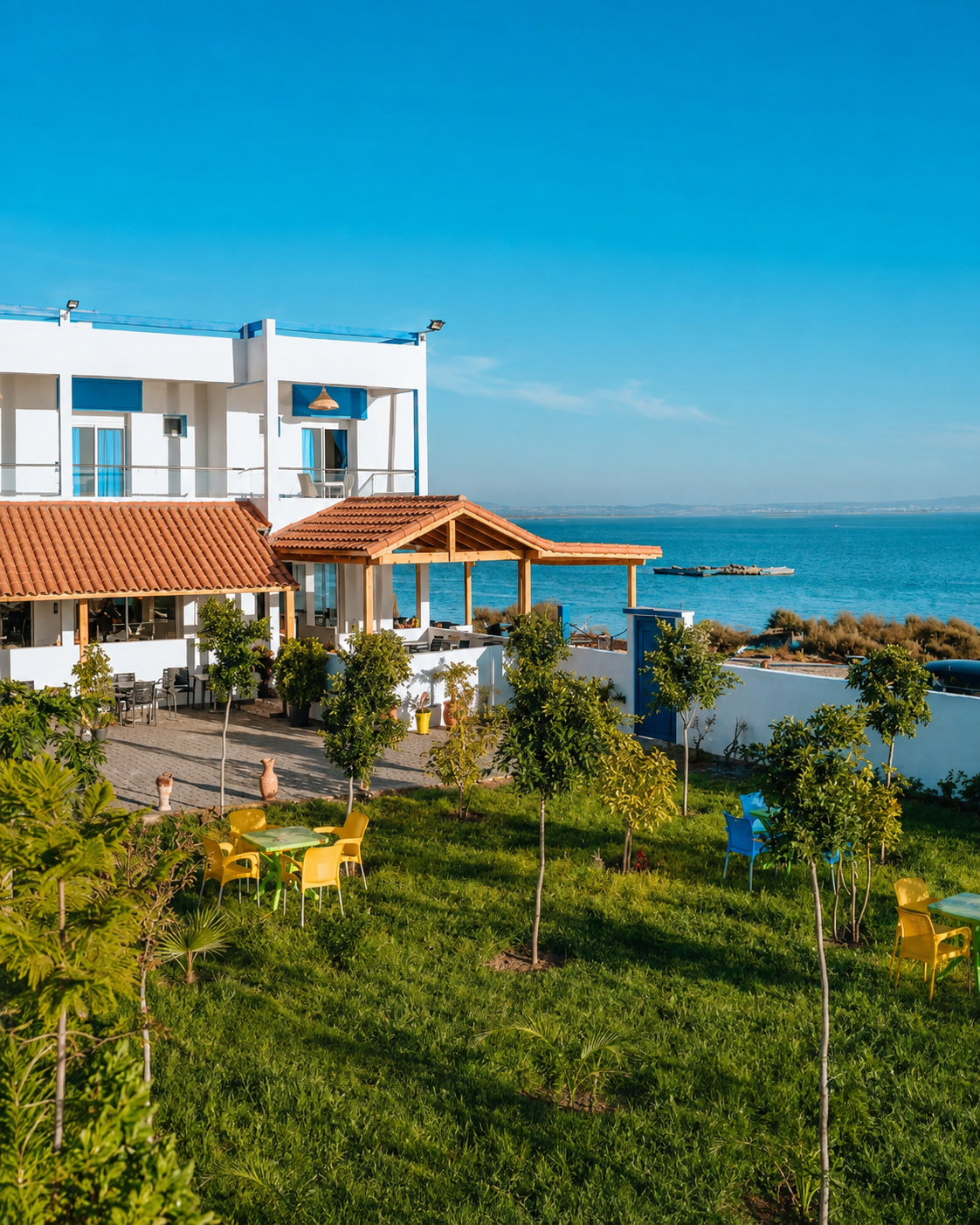 White seaside house with a garden, blue trim and an Atlantic view