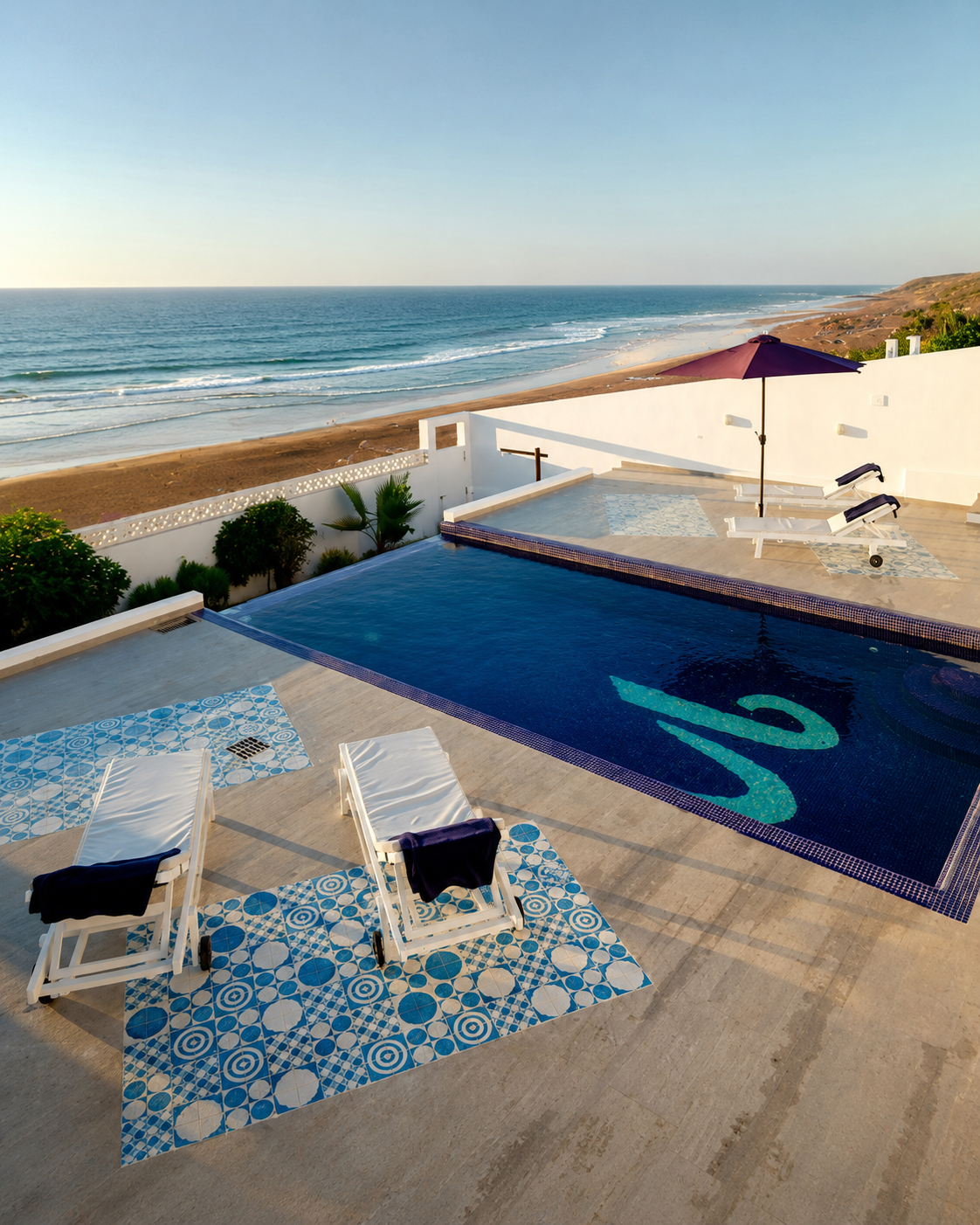 Sun loungers and a pool on a terrace overlooking the Atlantic beach
