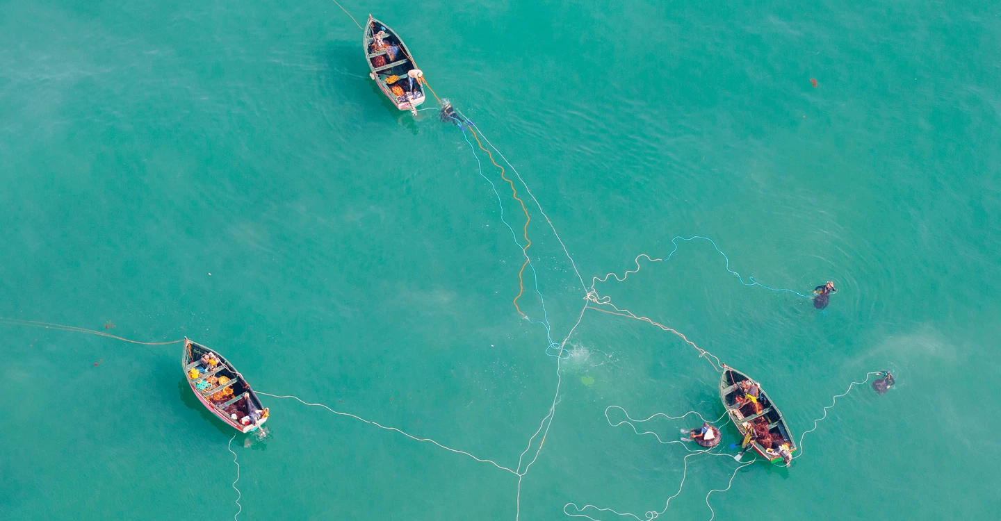 Three fishing boats and nets in the turquoise water of Oualidia lagoon