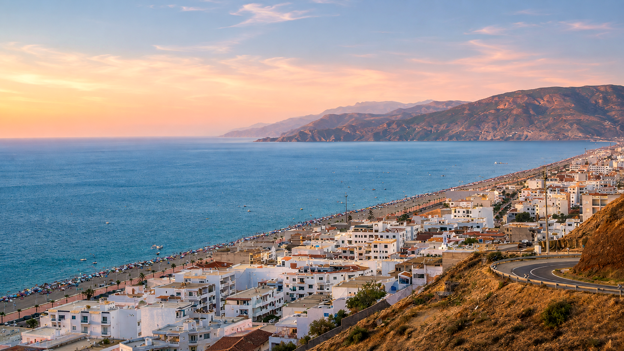 Oued Laou Coast at sunset with Mediterranean water, white town buildings and Rif mountain slopes