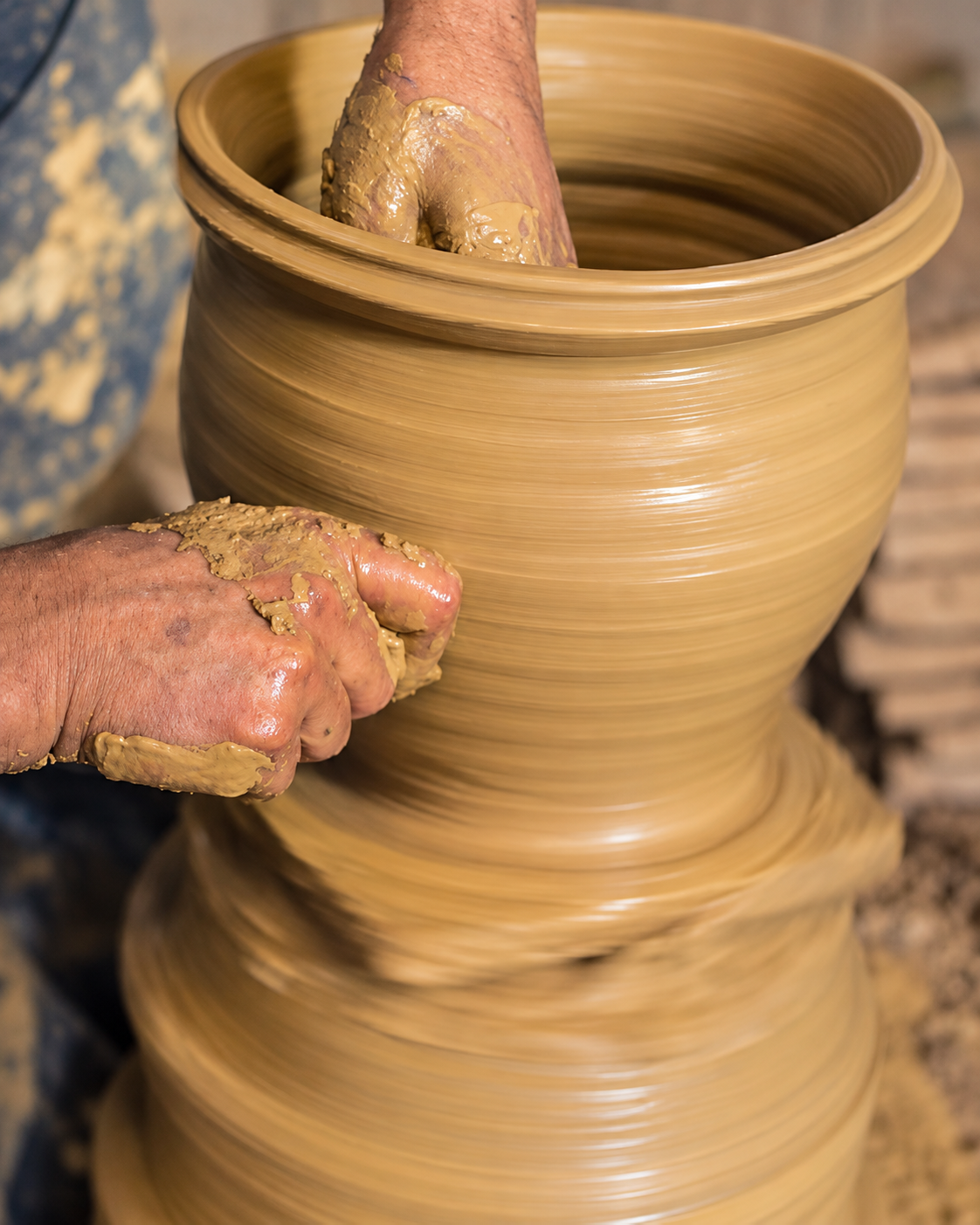 An Oulja artisan shaping a clay vessel by hand on a pottery wheel