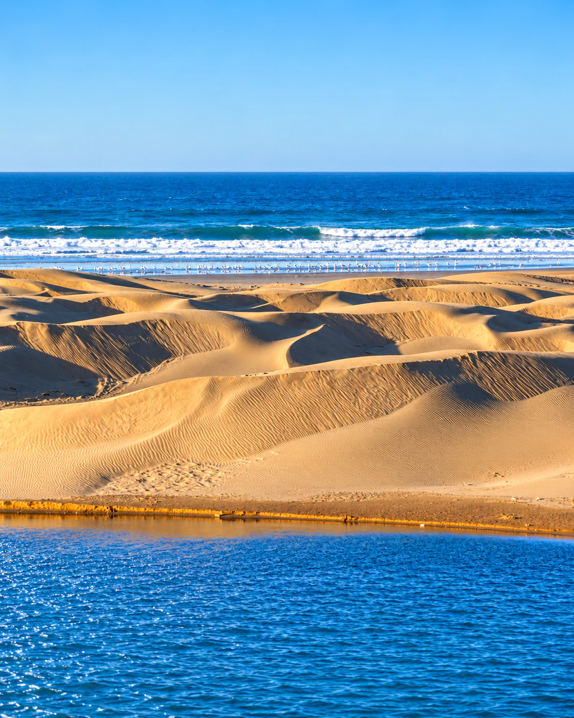 Dunes beside Khnifiss lagoon with the Atlantic Ocean beyond