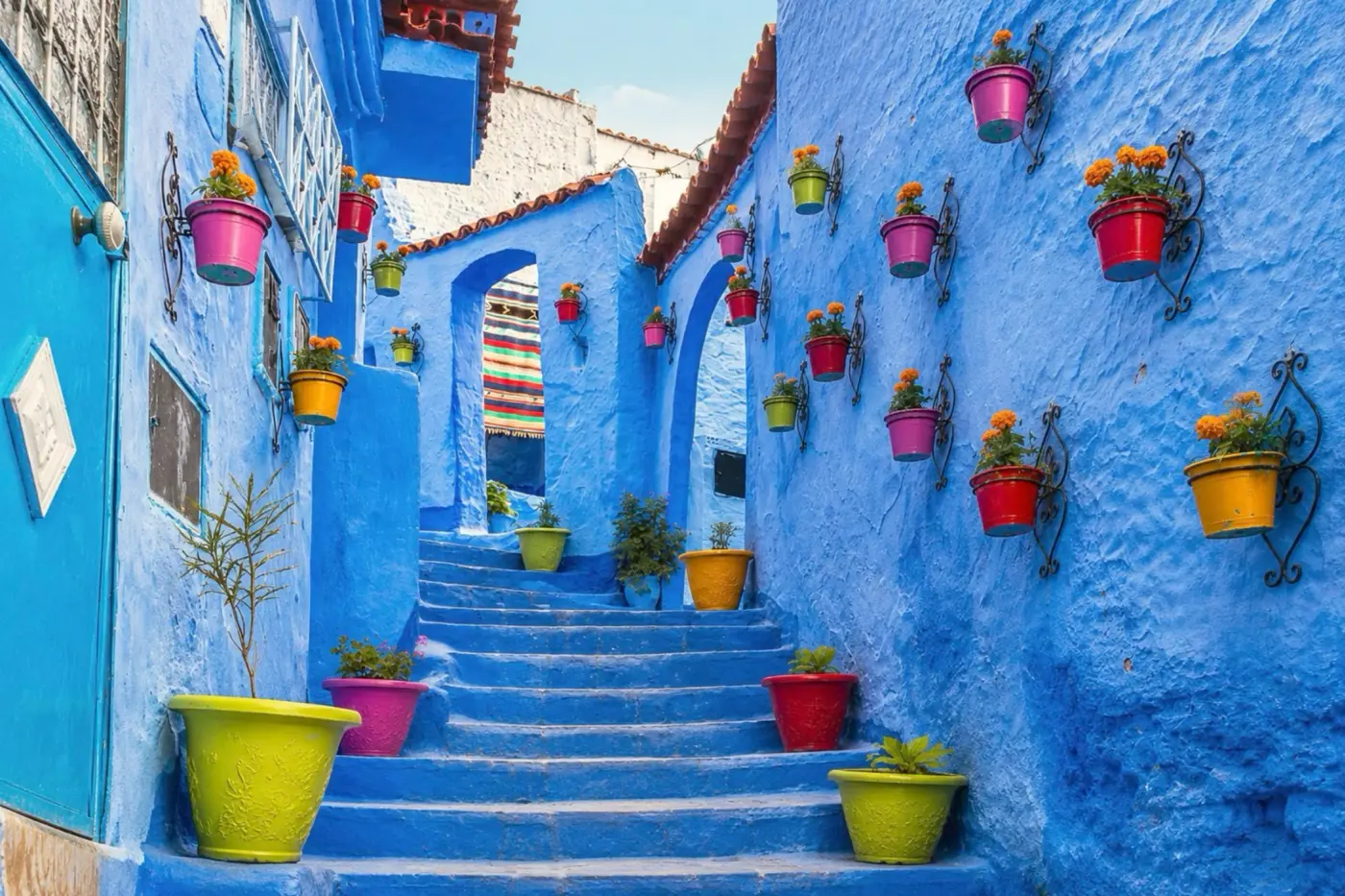 Blue streets and flower pots in Chefchaouen, the closest city context for Akchour