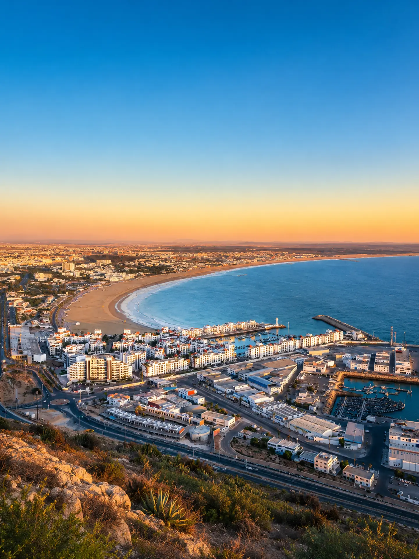 Agadir bay, marina and Atlantic coastline seen from above at warm evening light