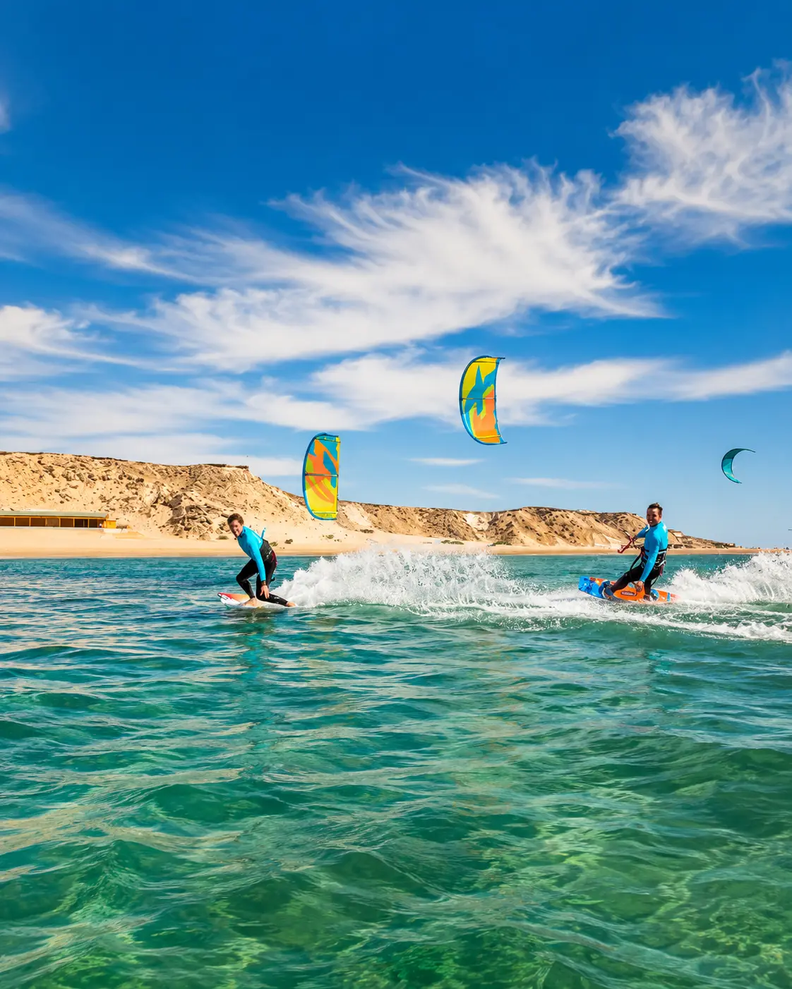 Kitesurfers riding across the clear water of Dakhla Lagoon