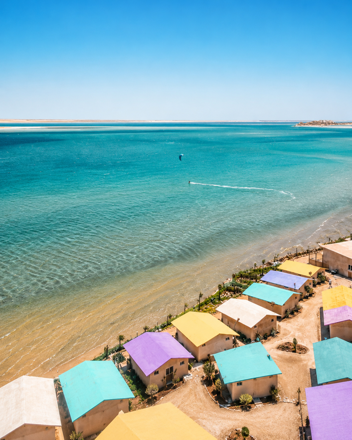 Dakhla lagoon view with turquoise water, shore buildings and open southern Moroccan sky