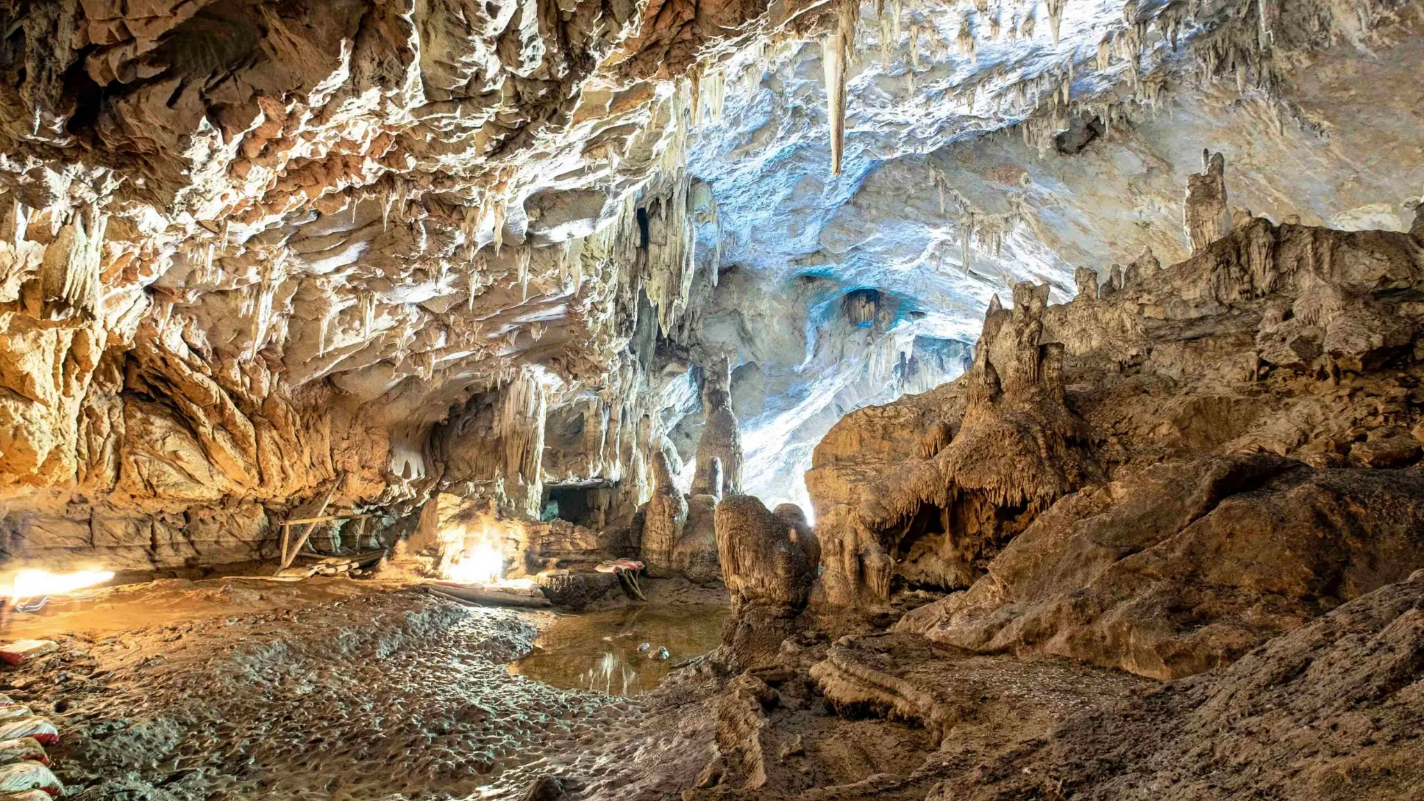 Illuminated limestone chambers and mineral formations inside Friouato Cave near Taza, Morocco